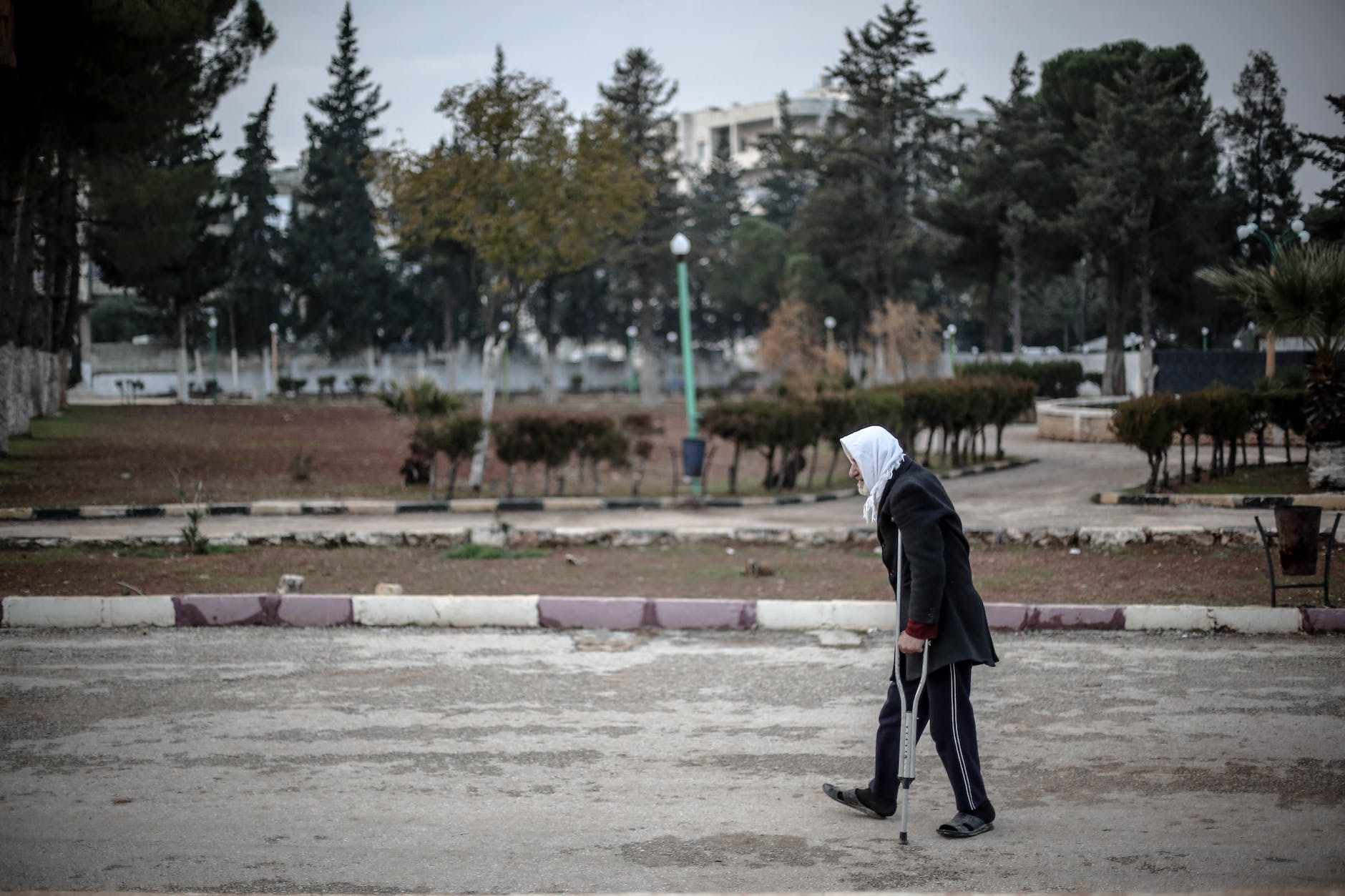 woman in hijab walking on crutches on street